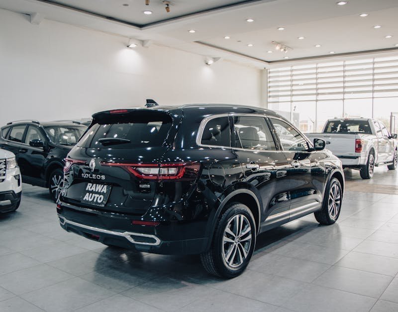 Spacious modern showroom featuring luxury cars on display.
