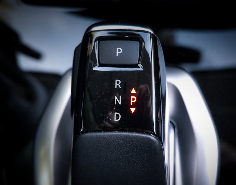 Detailed view of a modern automatic car gear shifter displaying P, R, N, D settings.