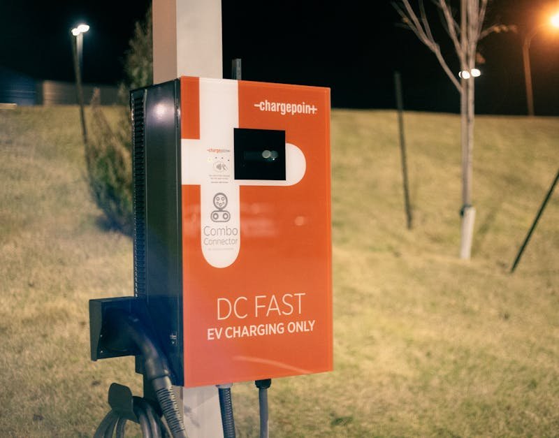 EV charging station at night with a blurred background, offering eco-friendly transportation solutions.
