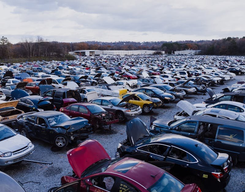 Wide view of a large car junkyard in Chattanooga with numerous vehicles showing signs of wear.