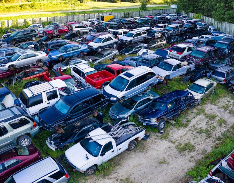 Aerial shot of a vehicle junkyard with rows of parked, damaged cars in Red Wing, Minnesota.