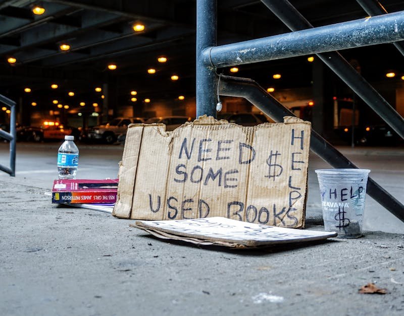 A help sign and used books in an urban setting highlight poverty in Chicago.
