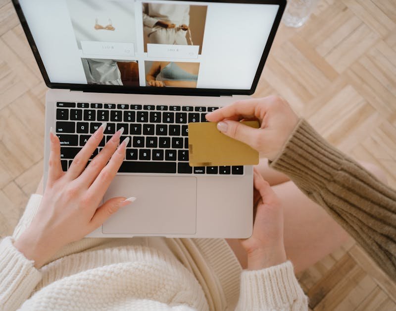Person shopping online using a laptop and credit card, highlighting e-commerce convenience.