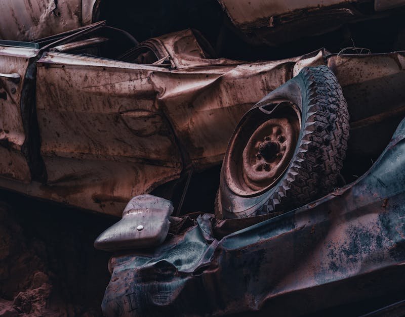 A dramatic view of stacked, rusty and abandoned cars in a junkyard, showcasing decay and abandonment.
