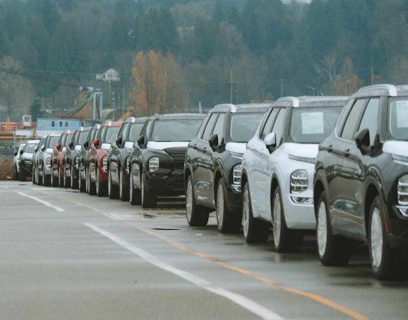 A line of new SUVs parked in an outdoor dealership lot, ready for sale.