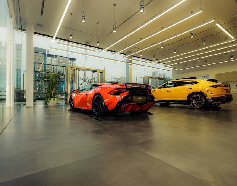 Showroom featuring luxury sports cars, Lamborghini models, with sleek design and modern architecture.