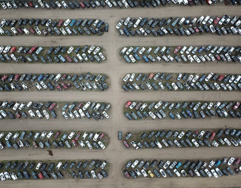 High angle view of numerous vehicles in an organized car lot, showcasing variety and structure.